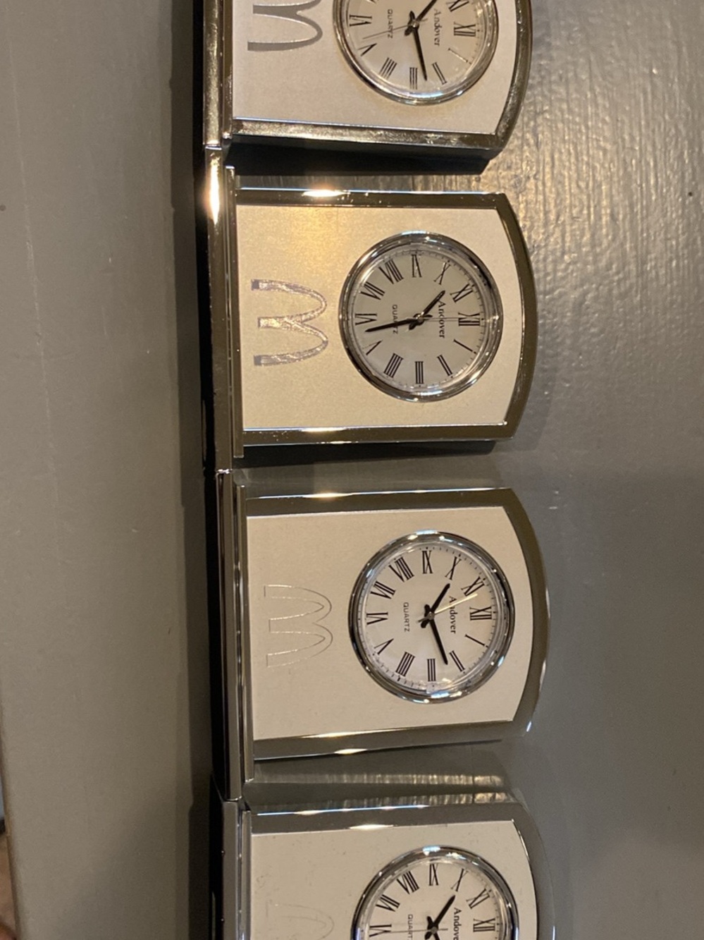 Four Silver mini clocks with Arch logo.